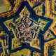 An aerial view of a small village built within the walls of a star-shaped fortress surrounded by a moat