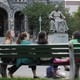 Students sit on a bench in front of a statute of the university founder John Carroll at Georgetown University.