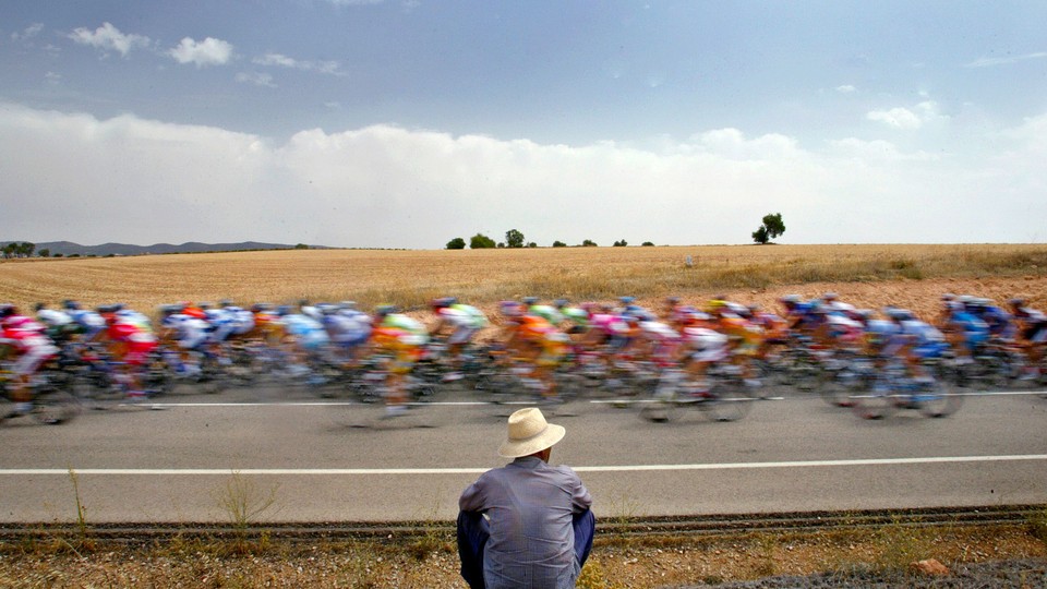 A man looks at a pack of bicyclists during the Tour of Spain in 2005.