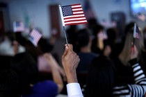 A new citizen waves an American flag during a naturalization ceremony.