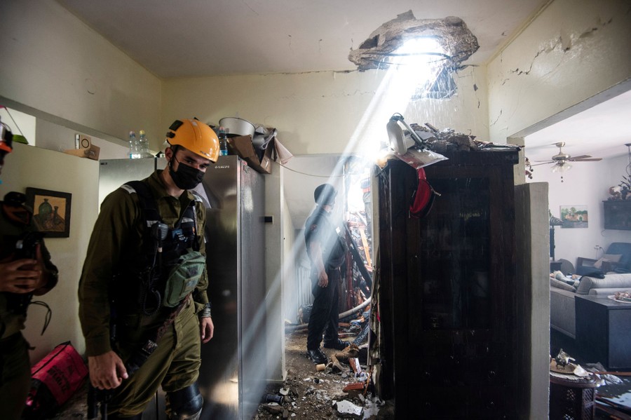 Soldiers walk through a damaged building.