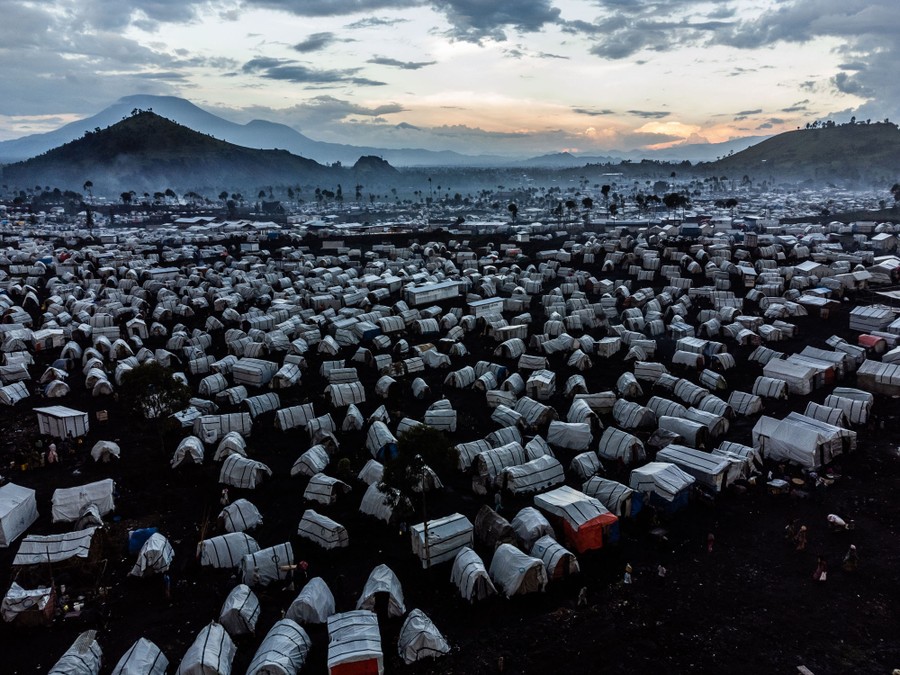 Hundreds of small tent shelters stand in a field.