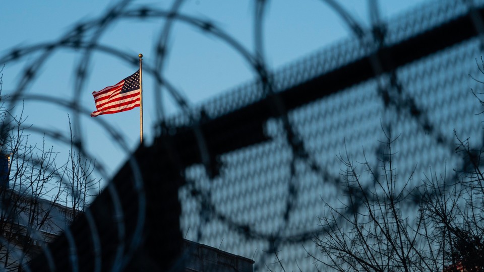 An American flag above a wire fence
