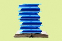 a stack of laptops on top of an open book