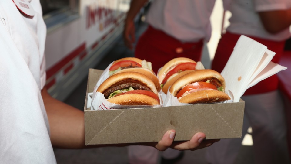 a photo of a man holding a box of hamburgers