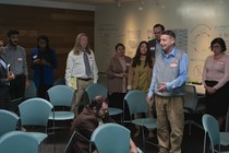 Tim Robinson stands in the middle of a conference room, drenched in water, while others stand around him, staring, in "I Think You Should Leave"