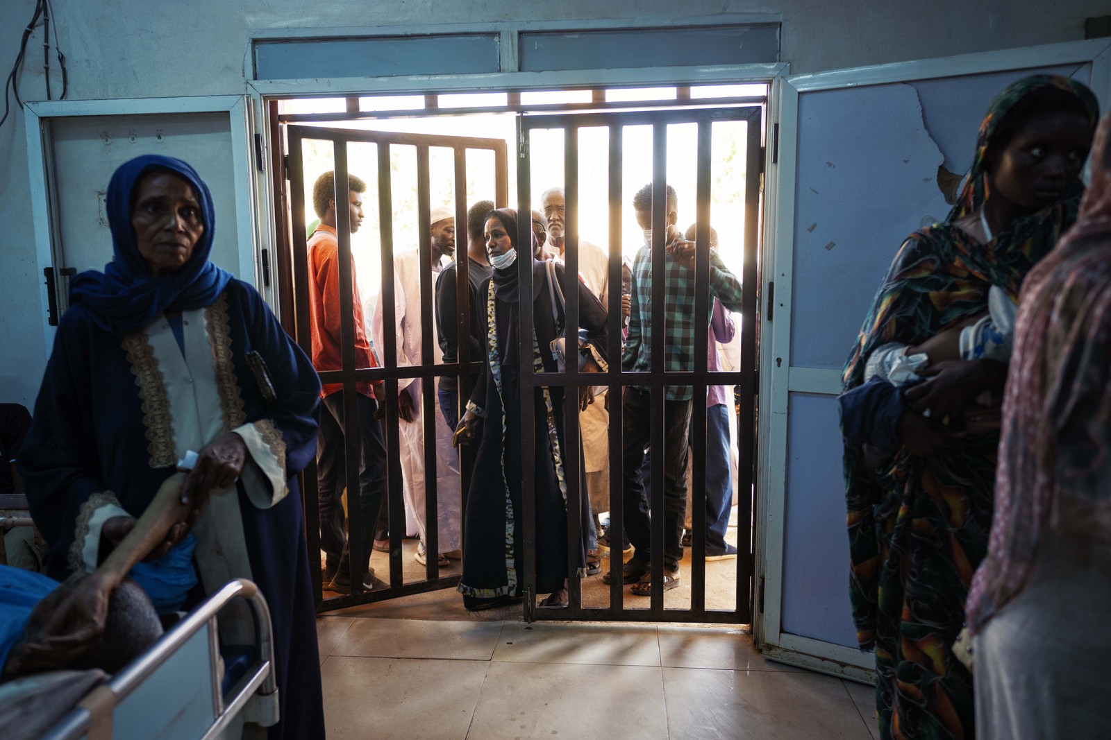 Sudanese civilians line up at the entrance to a ward where victims of recent RSF shellings are being treated.