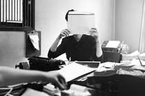 a woman in an office holds a folder covering her face