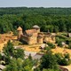 An aerial view of a small medieval-style castle in a wooded area