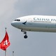 A Cathay Pacific plane hovers beside the flag of Hong Kong.