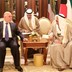 Iraq's prime minister, who is dressed in a suit, talks to the emir of Kuwait, who is dressed in traditional clothes. 