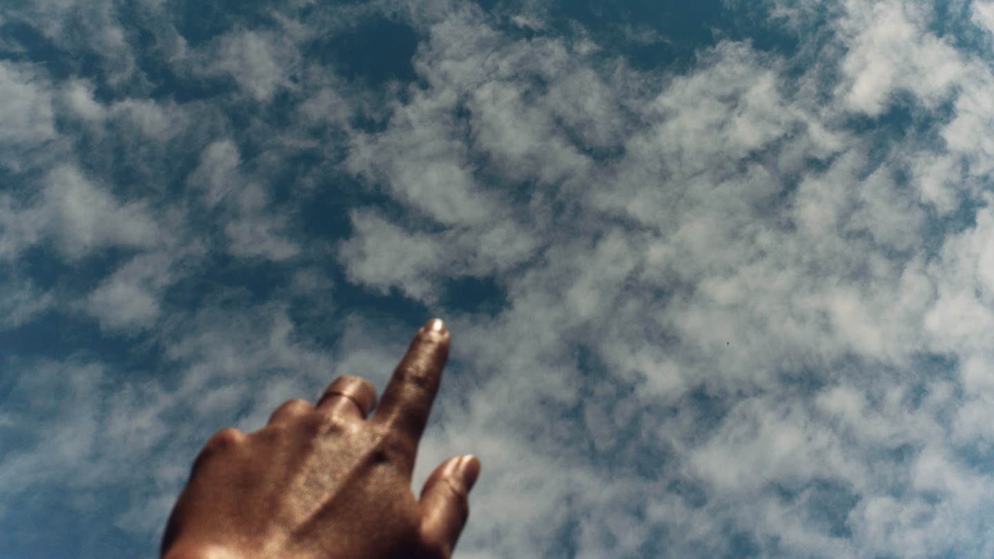 a photo of a hand outstretched toward the sky