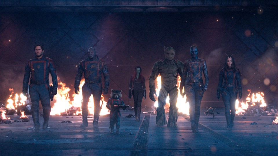 The Guardians of the Galaxy walking toward the camera with flames in the background