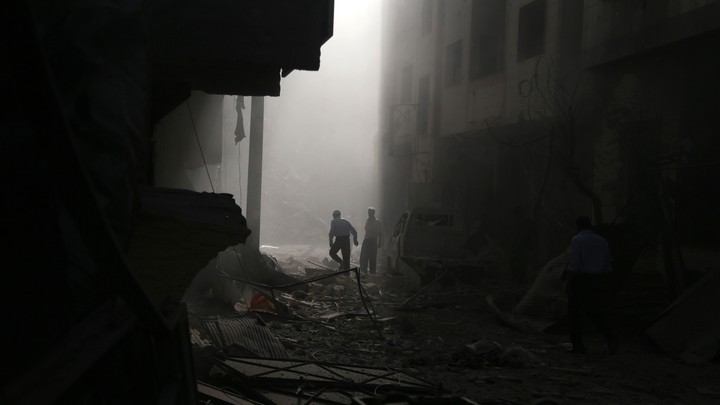 Residents inspect damage from what activists said was an air strike by forces loyal to Syrian President Bashar al-Assad on the town of Douma in Damascus, Syria, on October 2, 2015.