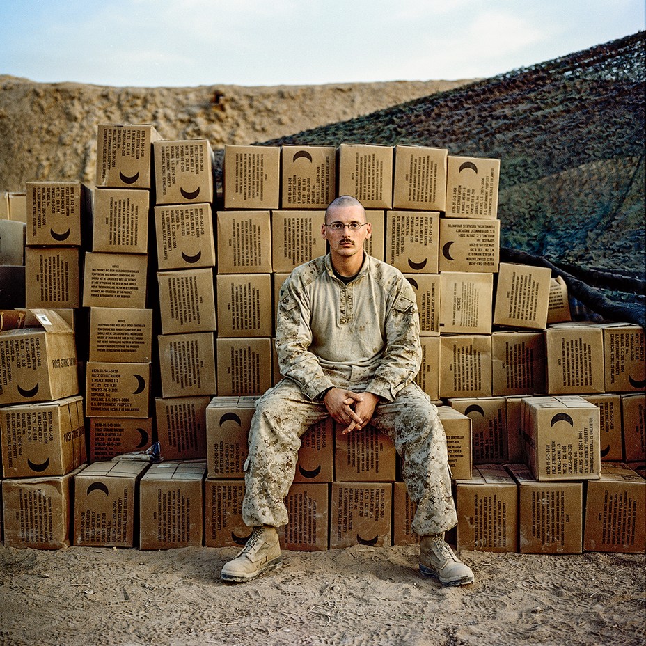 Soldier sits on stack of boxes