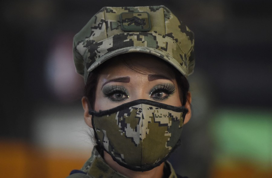 A portrait of a navy guard wearing a camouflage protective face mask.