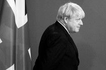 Boris Johnson walks past a British flag.