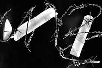 A broken candle with barbed wire wrapped around it