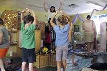 A teacher instructs preschool students in yoga. 