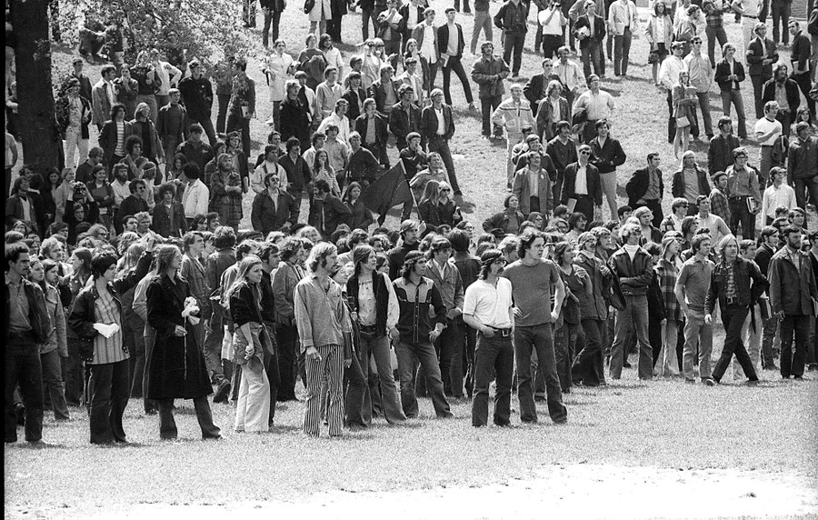 A crowd of student protesters stand at the base of a hill.