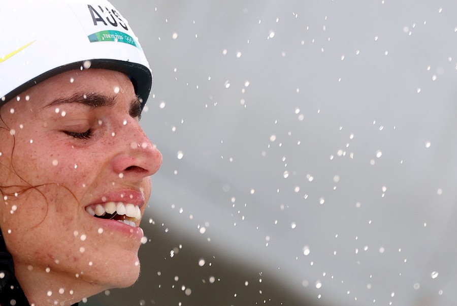 A woman's joyful face is pictured amid a spray of water.