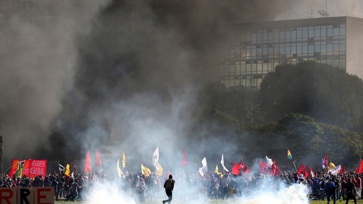 Smoke rises near Brazil’s Agriculture Ministry building during a protest against President Michel Temer and government corruption in Brasilia on May 24, 2017.