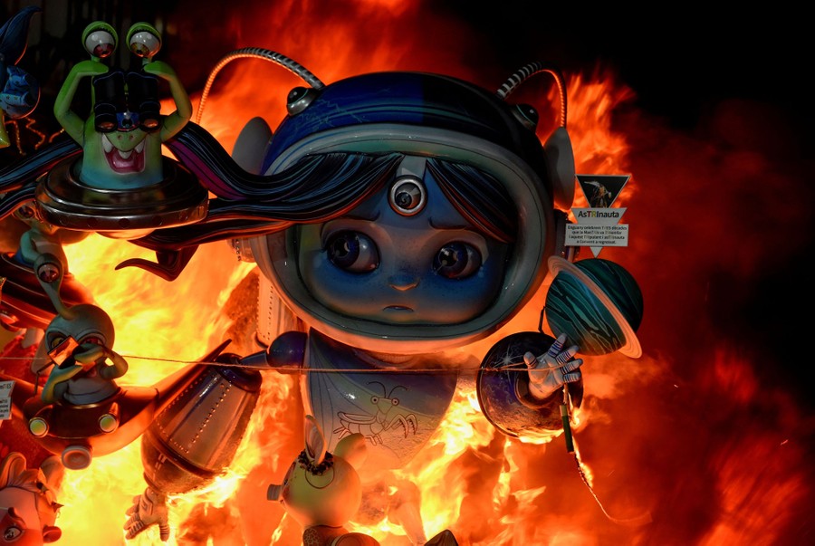A large cardboard sculpture of a cartoon astronaut, on fire