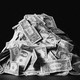 A photo of a pile of dollar bills, set against a black background