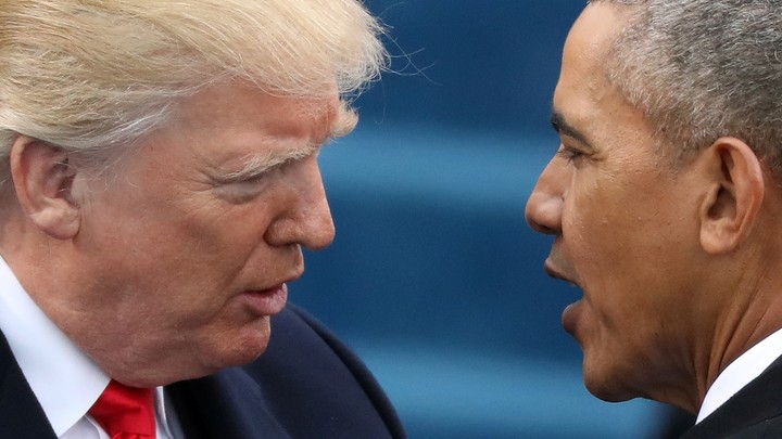 A close-up photo of Donald Trump and Barack Obama speaking to each other.