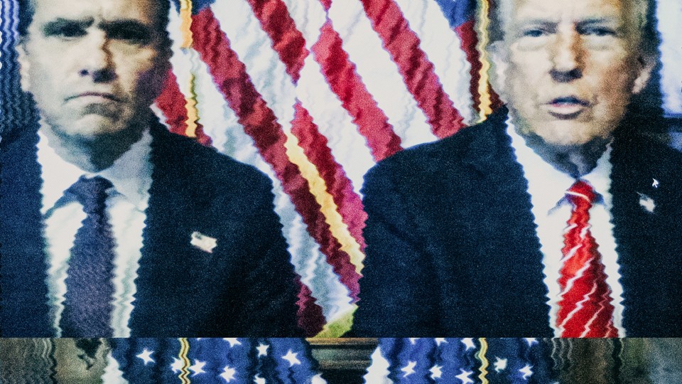 Todd Blanche and Donald Trump sit next to each other in front of American flags.