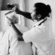 A health aide helps comb the hair of an elderly person
