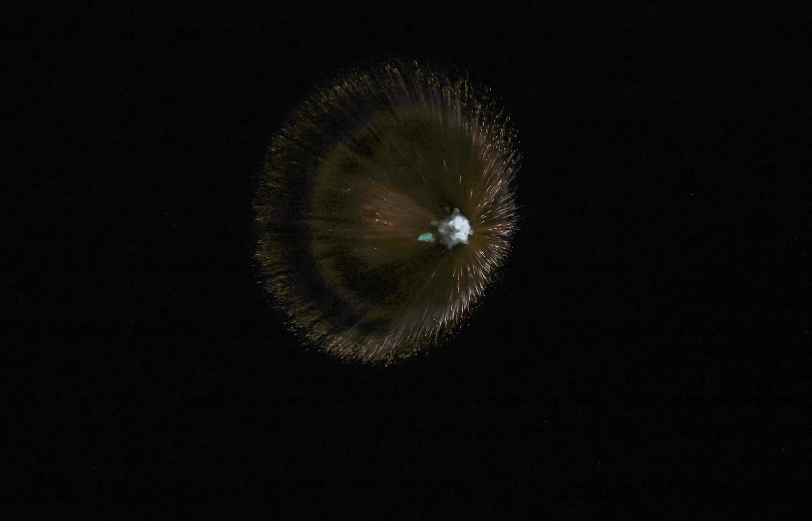 An exploding missile, seen in the air, against a dark sky.