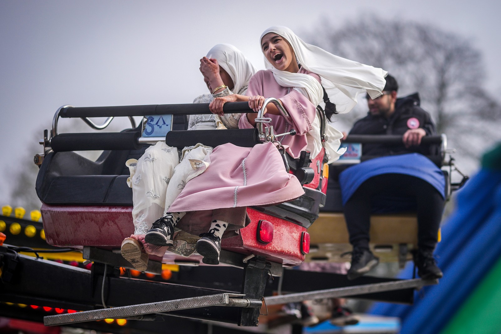People laugh, enjoying an amusement park ride.