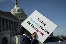 A person holds a sign in front of the Capitol that reads, "TikTok changed my life for the better."