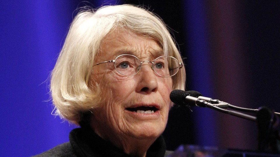 The poet Mary Oliver speaks at a podium.