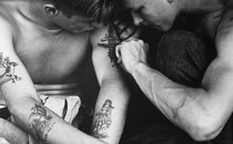 a black-and-white photo of someone getting their upper arm tattooed