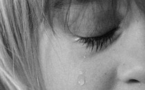 Cropped black-and-white close-up image of a child crying