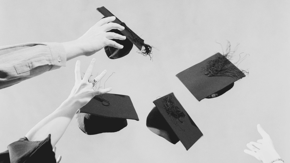 A photo of graduating students throwing caps in the air