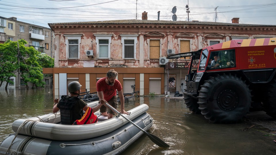 Rescue workers paddle a boat through flooded streets in Kherson.