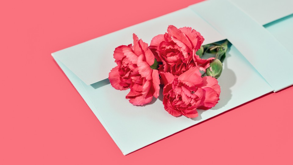 An image of pink carnations tucked in an envelope.