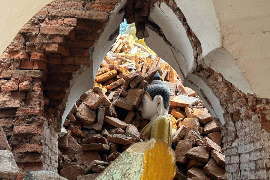 A damaged pagoda, showing bricks piled atop a religious statue.