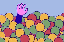 A hand reaching up from a ball pit