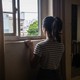 A woman looks out a window