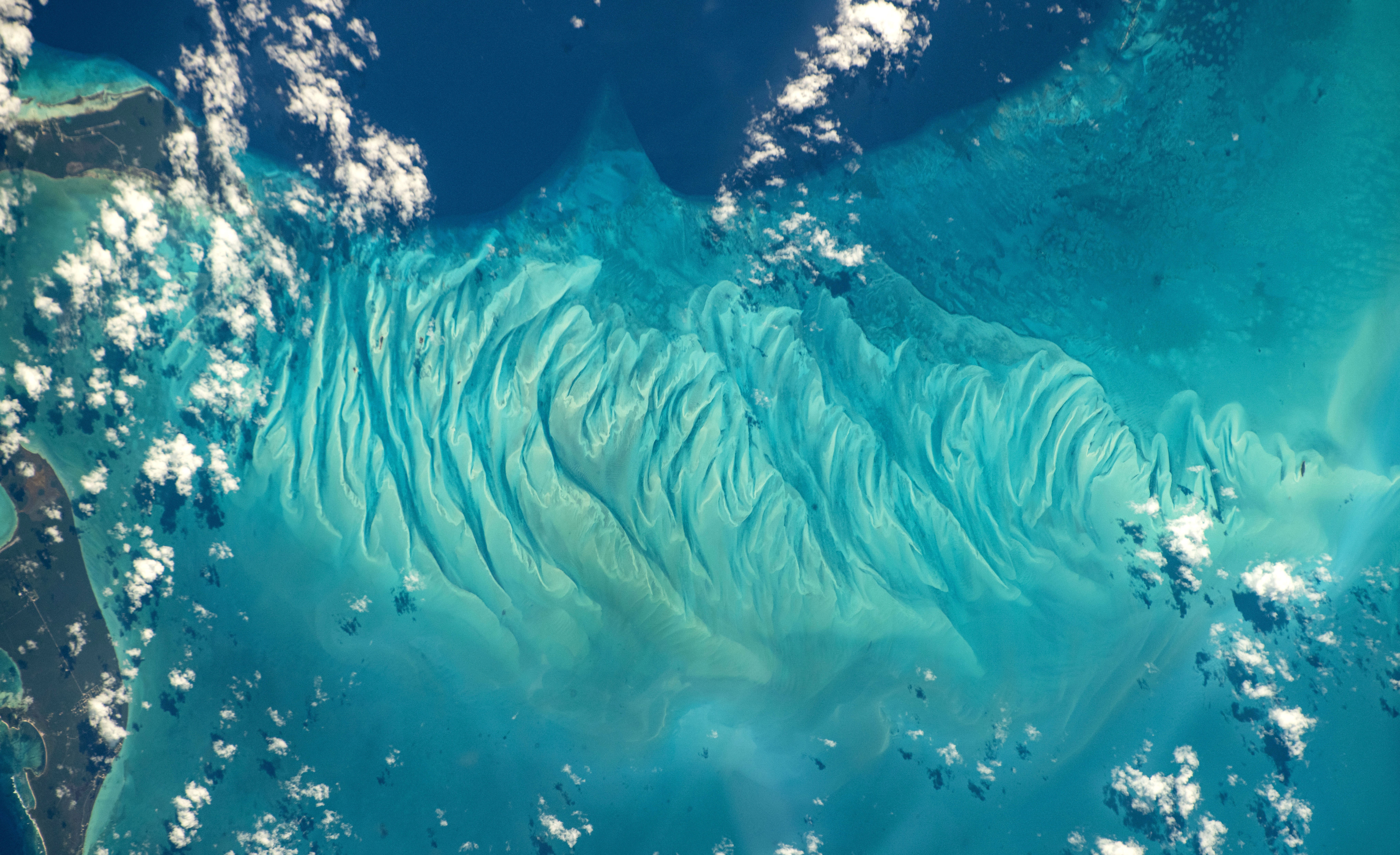 Swirling formations in the shallow sea floor, seen from orbit