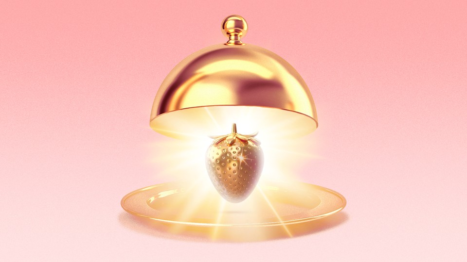 A golden strawberry gleaming on a golden platter