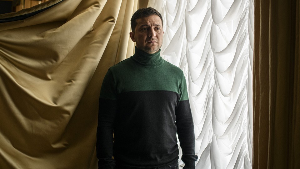 Ukraine's leader stands in front of a window.