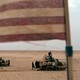 A photograph of tanks with an American flag in the foreground