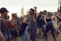 A crowd of people dancing in the desert