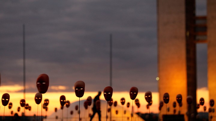 A man walks past masks in Brasilia.