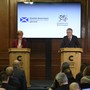 Nicola Sturgeon and Mark Drakeford stand at podiums while delivering a press conference.
